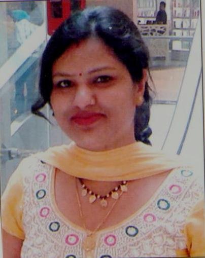 Portrait of Dr. Kapoor wearing traditional attire with academic books in background